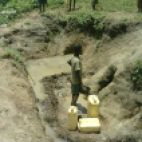 Boy fetching water from an unprotected spring